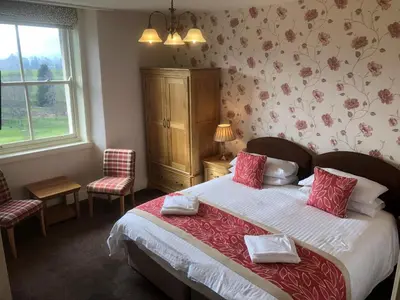 a bedroom with a large bed with red and white pillows at Crow Park Hotel in Keswick
