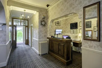 a hallway with a desk and a mirror at Crow Park Hotel in Keswick