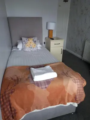 a bedroom with a bed with two towels on it at Crossroads House in Carlisle
