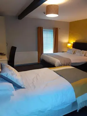 a hotel room with two beds and a window at Crossroads House in Carlisle