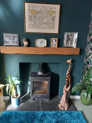 a living room with a fireplace with a clock on a shelf at Crossroads House in Carlisle