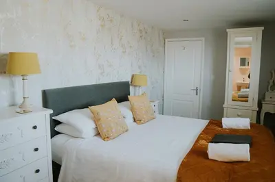 a bedroom with a large white bed with pillows at Crossroads House in Carlisle
