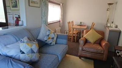 a living room with a couch and chairs and a table at 11 Laigh Isle in Isle of Whithorn