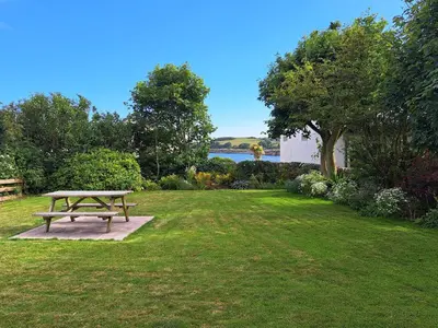 a picnic table sitting in the middle of a lawn at 11 Laigh Isle in Isle of Whithorn