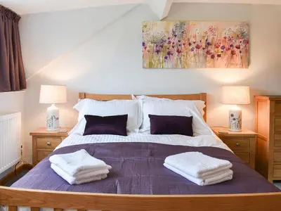 a bedroom with a large bed with towels on it at Hovera in Glenridding