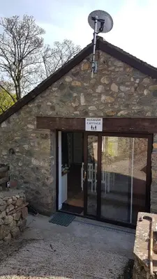 a stone building with a door with a sign on it at Windsor Cottage on The Big 