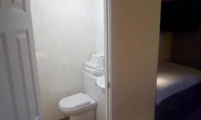 a small bathroom with a toilet and towels at The Townhouse Self Catering in Dumfries