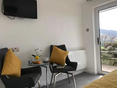 a living room with two chairs and a table with yellow pillows at The Bungalows Guesthouse in Threlkeld