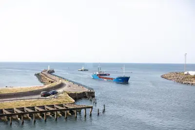 a large blue boat in the water next to a dock at Arran View - Coorie Doon Stays in Ayr