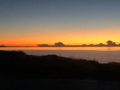 a sunset over a body of water at Dove cottage in Allonby