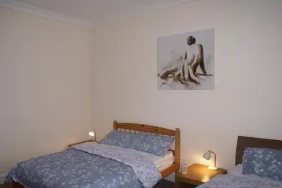 a bedroom with two beds and a picture on the wall at Mid Flat in Dumfries