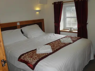 a bedroom with a bed with two towels on it at OLD BAKEHOUSE in Holmrook