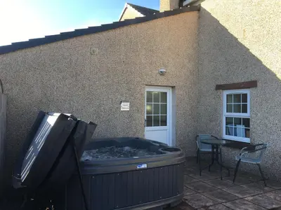 a trash can and a grill outside of a house at OLD BAKEHOUSE in Holmrook