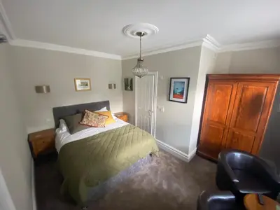 a bedroom with a bed and a chair at Claremont House Keswick in Keswick