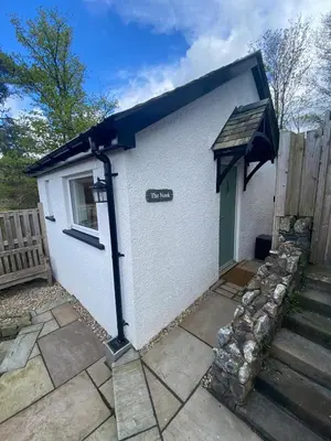 a small white building with a sign on it at Claremont House Keswick in Keswick