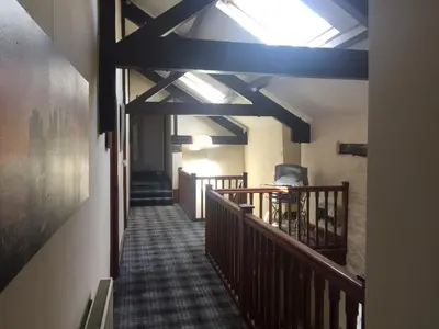 a hallway with a staircase with wooden beams and a ceiling at Fairladies Barn Guest House in St Bees