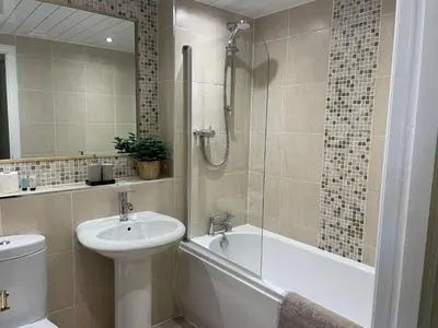 a bathroom with a tub and a sink and a shower at Kintyre Apartment in Ayr