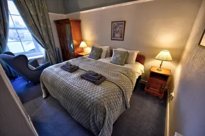 a hotel room with a bed with towels on it at Burnside Guest House in Ayr