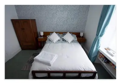 a bedroom with a bed with white sheets and pillows at Cornmill House, With Outstanding Sea Views In Garlieston in Garlieston
