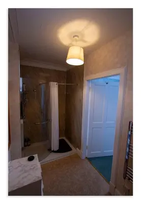 a bathroom with a shower and a white door at Cornmill House, With Outstanding Sea Views In Garlieston in Garlieston