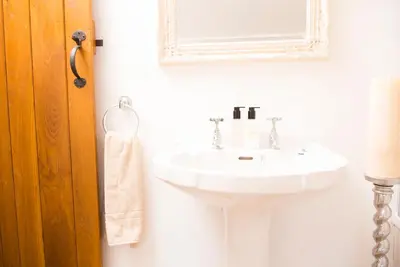 a bathroom with a white sink and a mirror at The Nook Cottage in Carlisle