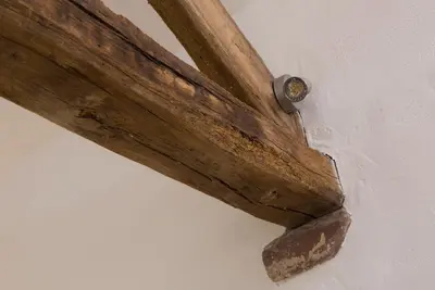 a wooden beam with a clock on a wall at The Nook Cottage in Carlisle