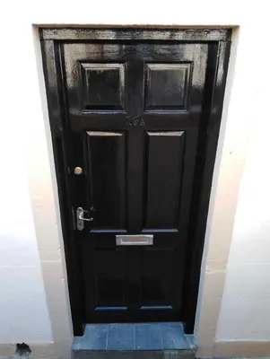 a black door with a cat sitting in front of it at The Nook - Coorie Doon in Ayr