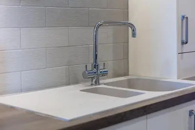 a kitchen sink with a faucet on a counter at Bay View - Donnini Apartments in Ayr