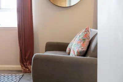 a couch with a pillow on it in a living room at Bay View - Donnini Apartments in Ayr