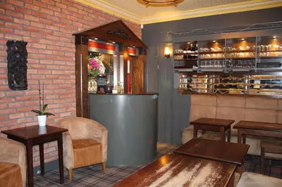 a restaurant with a table and chairs and a bar at The Kirkcudbright Bay Hotel in Kirkcudbright