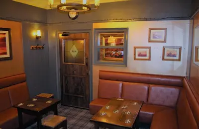 a bar with a bench and a table and a door at The Kirkcudbright Bay Hotel in Kirkcudbright