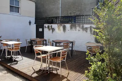 a bunch of tables and chairs on a deck at The Kirkcudbright Bay Hotel in Kirkcudbright