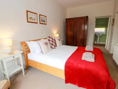 a bedroom with a bed with a red blanket on it at Cairnhill in Girvan