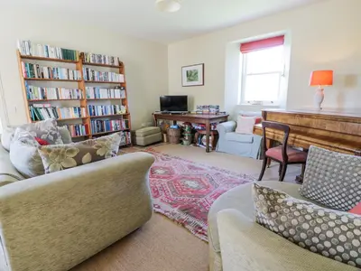 a living room with two couches and a piano at Marl House in Newton Stewart