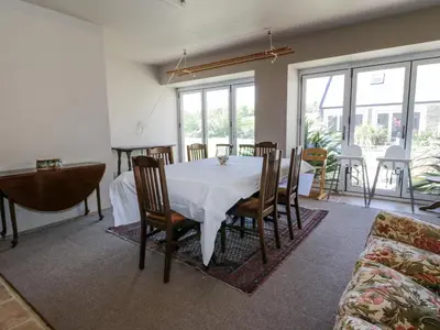 a dining room with a white table and chairs at Marl House in Newton Stewart