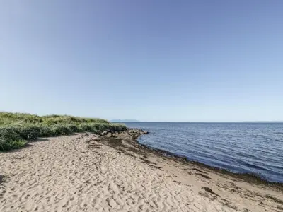 a sandy beach next to a body of water at Bright and Beautiful in Ayr