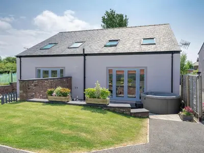 a house with a bath tub in a yard at Coney Garth Cottage in Beckermet