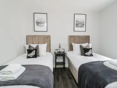 two twin beds in a room with white walls at 8 Bridge Street in Cockermouth