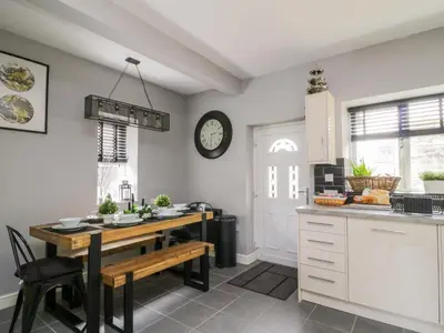 a kitchen with a table and a clock on the wall at 8 Bridge Street in Cockermouth