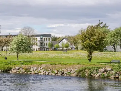a view of a river with buildings in the background at 8 Bridge Street in Cockermouth