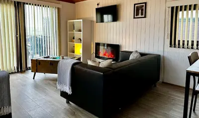 a living room with a couch and a fireplace at Lodge Cabin with Fabulous Views - Farm Holiday in Stranraer