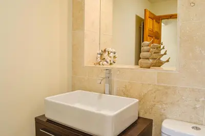 a bathroom with a white sink and a mirror at The Fairways in Portpatrick