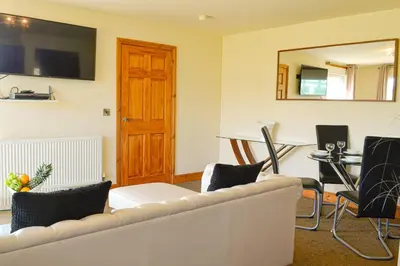 a living room with a white couch and a table at The Fairways in Portpatrick