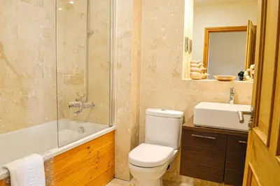 a bathroom with a toilet and a shower and a sink at The Fairways in Portpatrick