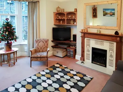 a living room with a fireplace and a christmas tree at Robinson in Keswick