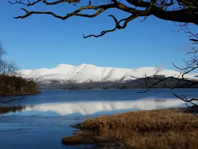 a view of a lake with snow covered mountains in the background at Field House Lodge in Borrowdale Valley