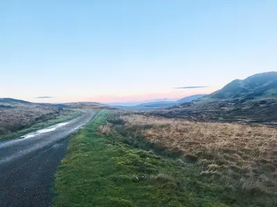 an empty road in the middle of a field at Ramerish Retreat in Laurieston
