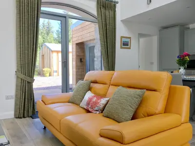 an orange couch in a living room with a window at Ramerish Retreat in Laurieston