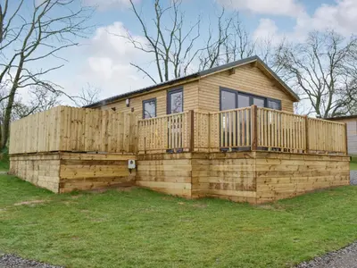 a house built on a retaining wall with a deck at Osprey Lodge in Westward