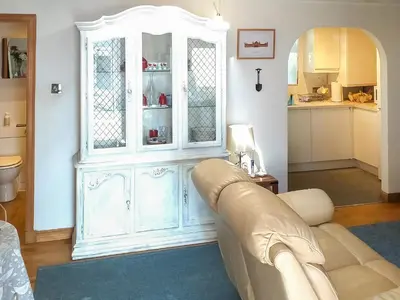 a living room with a white cabinet and a couch at Honeysuckle Cottage in Springside
